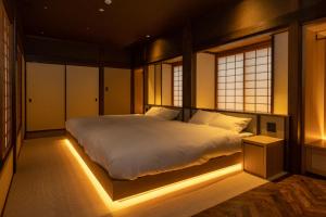 Hagi No Yado Tomoe في هاجي: غرفة نوم فيها سرير واضاءة