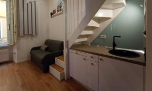 a bathroom with a sink and a staircase in a room at Tolli Colosseo Apartment in Rome