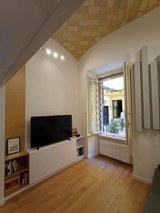 a living room with a flat screen tv and a window at Tolli Colosseo Apartment in Rome