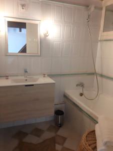 a bathroom with a sink and a tub and a mirror at Appartement le Mehari in Cassis