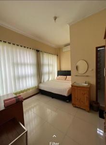 een slaapkamer met een bed en een spiegel bij G10 Guest House Near Asia Afrika Bandung in Bandung