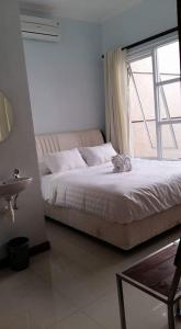 a bedroom with a large bed with a window at G10 Guest House Near Asia Afrika Bandung in Bandung