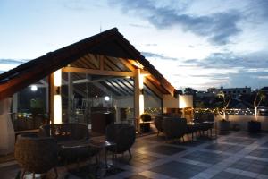 eine Terrasse mit Stühlen und Tischen auf dem Dach in der Unterkunft G10 Guest House Near Asia Afrika Bandung in Bandung