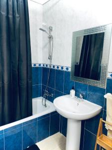 y baño azul y blanco con lavabo y ducha. en Refugio de Tranquilidad en Gran Alacant, en Gran Alacant