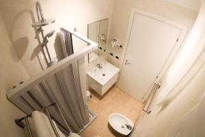 łazienka z umywalką, toaletą i lustrem w obiekcie Soave Rooms w mieście Neapol +33 zdjęcia