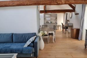 uma sala de estar com um sofá azul e uma mesa em L'Angelus de Villiers, belle suite dans corps de ferme em Villiers-sous-Grez