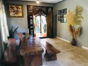 a living room with a wooden table and a door at Yasa Backpackers house in Ubud