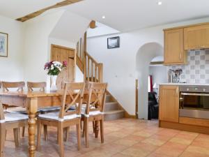 a kitchen and dining room with a wooden table and chairs at The Old Stables in Sherston