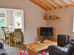 a living room with a television and a table with a fireplace at Wold View in Gristhorpe