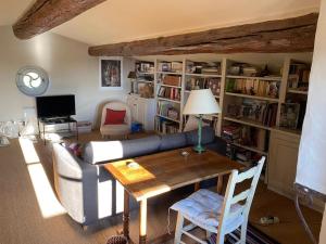 a living room with a couch and a table at In Gordes, facing the entire Luberon Park a beautiful 5 bedrooms house in Gordes