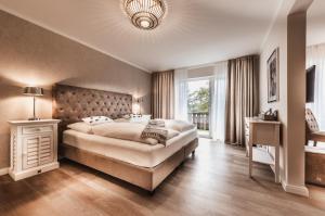 a bedroom with a large bed and a large window at Aparthotel Friesenhof in Wenningstedt