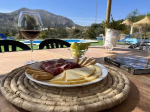 een bord eten en een glas wijn op een tafel bij Mirador de Shilpa y Sonal in Valle de Abdalagís