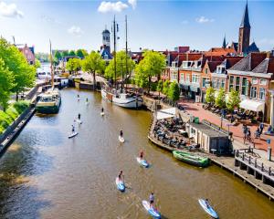 een groep mensen in boten in een rivier bij Logementen Dokkum in Dokkum