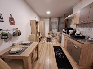 a kitchen with a table and a counter top at Sweet apartment in Subotica