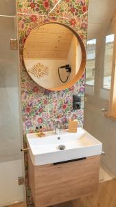 La salle de bains est pourvue d'un lavabo et d'un miroir. dans l'établissement Apartamenty Osada Biała Woda Szczawnica Jaworki 1km od stoku, à Szczawnica