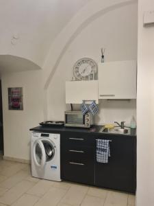 a kitchen with a washing machine and a sink at La Cattedrale in Bisceglie