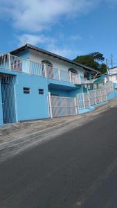 un bâtiment bleu avec une clôture blanche à côté d'une rue dans l'établissement Pousada Bela Vista, à Castro