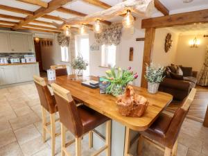 a kitchen and living room with a wooden table and chairs at Tawny Owl Cottage in Louth