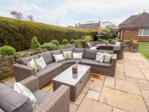 a patio with a couch and chairs and a table at Tawny Owl Cottage in Louth
