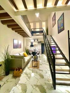 a living room with a staircase and a couch at SoHo Loft in Alexandroupoli