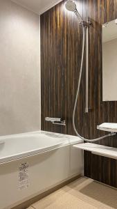 a bathroom with a shower and a bath tub at Hagi No Yado Tomoe in Hagi
