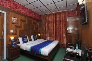 a bedroom with a bed and a television in it at Goroomgo Ankur Lake View Mall Road Nainital - Prime Location with Luxury Room in Nainital