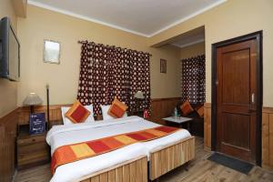 a bedroom with a large bed and a television at Goroomgo Ankur Lake View Mall Road Nainital - Prime Location with Luxury Room in Nainital
