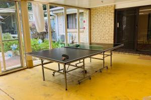 a ping pong table in the middle of a room at Relaxing at acreage farmhouse in Burrawang