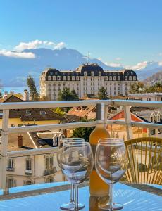 Dois copos de vinho numa mesa na varanda em Penthouse vue incroyable lac et montagnes em Annecy