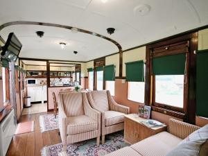 a train room with chairs and a couch and a table at Railway Carriage Two - E5601 in Wetheringsett