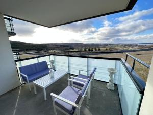 d'un balcon avec des chaises bleues, une table et une vue. dans l'établissement Modern 2 bedroom apartment in Kópavogur, à Reykjavik