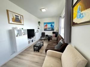 a living room with two couches and a flat screen tv at Modern 2 bedroom apartment in Kópavogur in Reykjavík