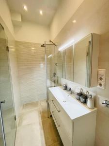 a bathroom with a white sink and a shower at Podmaniczky Deluxe Apartment in Budapest