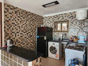 a kitchen with a refrigerator and a washing machine at شقة مصيف الاسكندرية - البيطاش بيانكي in Alexandria