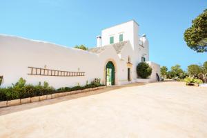 une grande maison blanche avec une grande allée dans l'établissement Masseria San Michele, à Martina Franca