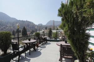 a patio with tables and chairs on a balcony at Goroomgo Ankur Lake View Mall Road Nainital - Prime Location with Luxury Room in Nainital