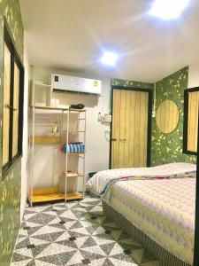 - une chambre avec un lit et une porte dans l'établissement Chompunud House589 ชมพูนุชเฮ้าส์589, à Ban Don Klang
