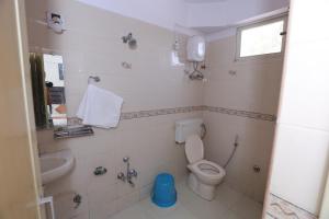 a small bathroom with a toilet and a sink at HOTEL RUNWAY INN in Ahmedabad