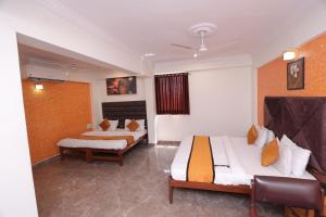 a hotel room with two beds and a window at HOTEL RUNWAY INN in Ahmedabad