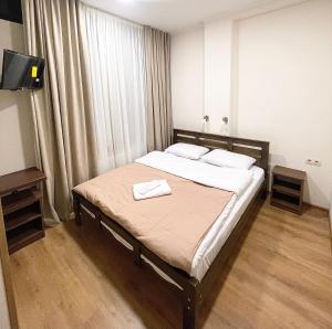 een slaapkamer met een bed met twee handdoeken erop bij ART family hotel in Tbilisi City