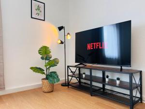 TV de pantalla plana en la parte superior de una mesa en BIG-6-Guests-Kingsize-Netflix-Badewanne-Hauptbahnhof-Zentral en Koblenz