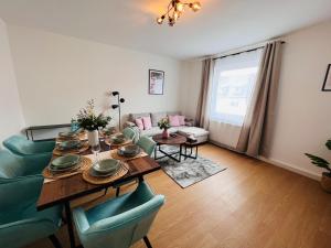 uma sala de estar com uma mesa e cadeiras azuis em BIG-6-Guests-Kingsize-Netflix-Badewanne-Hauptbahnhof-Zentral em Koblenz