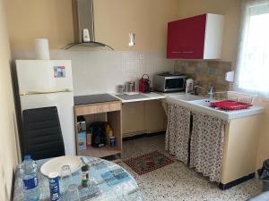 a small kitchen with a white refrigerator and a sink at CALME in Drancy