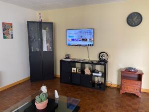 a living room with a tv on a wall at CALME in Drancy