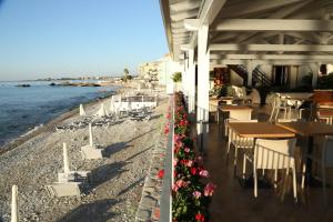 a restaurant on the beach with tables and chairs at Sirina House Taormina in Taormina