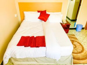 a bed with red and white pillows on it at Spring Hills Hotel - Morogoro in Morogoro +5 photos