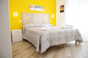 a bedroom with a bed and a yellow wall at B&B DieMme Amalfi Coast in Vietri sul Mare