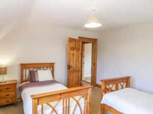 um quarto com 2 camas individuais e uma secretária em Kiltymon Cottage em Ahakista