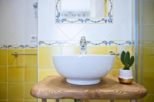 a bathroom with a bowl sink and a cactus on a stool at B&B DieMme Amalfi Coast in Vietri sul Mare