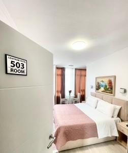 a bedroom with a bed and a sign that reads sidx room at Centrum Hotel in Tirana